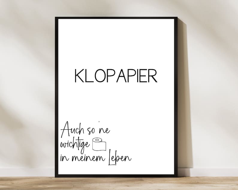 Op de afbeelding: Zwart-witte printbare wandkunst met de tekst "KLOPAPIER" en "Auch so 'ne wichtige in meinem Leben".