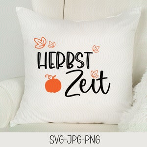 Puede incluir: Almohada blanca con el texto "HERBST ZEIT" en letras negras y un pequeño gráfico de calabaza naranja. Hay pequeños gráficos de hojas naranjas alrededor del texto.