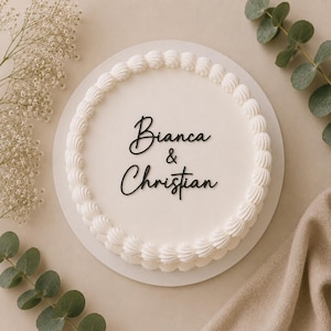 Può includere: Una torta rotonda bianca con una superficie glassata liscia e un bordo decorativo a ciuffi lungo il perimetro. Al centro, un topper per torta nero in corsivo riporta i nomi Bianca & Christian con un carattere chiaro ed elegante.