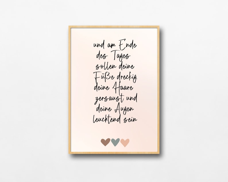 May include: A framed print with a pink background and white text that reads "und am Ende des Tages sollen deine F&uuml;&szlig;e dreckig deine Haare zersaust und deine Augen leuchtend sein". Three small hearts are at the bottom of the print, one brown, one gray, and one pink.