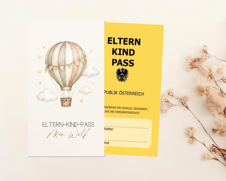 May include: A white card featuring a watercolor hot air balloon with clouds and stars, labeled ELTERN-KIND-PASS and Mia Wolf. Beside it, a yellow card titled ELTERN KIND PASS REPUBLIK &Ouml;STERREICH with an eagle emblem and blank lines for names.