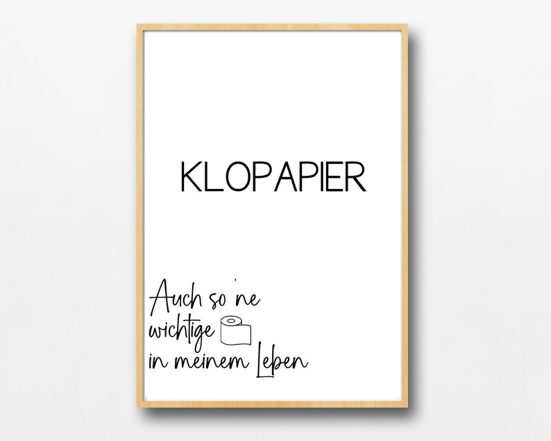 Op de afbeelding: Een witte ingelijste print met zwarte tekst die "KLOPAPIER" en "Auch so 'ne wichtige in meinem Leben" luidt, met een eenvoudige lijntekening van een rol toiletpapier.