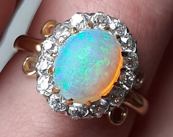 Een antieke Edwardiaanse 18 kt gouden opaal en diamanten clusterring
