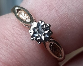 Puede incluir: Un anillo de oro con un solo diamante engastado en garras. La banda es fina y tiene un diseño delicado.