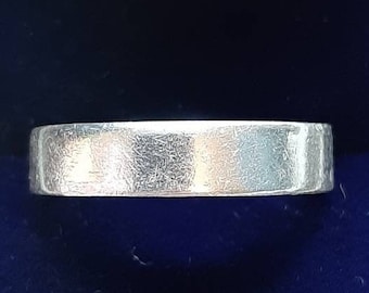 Puede incluir: Una alianza de plata en una caja de anillo de terciopelo azul.