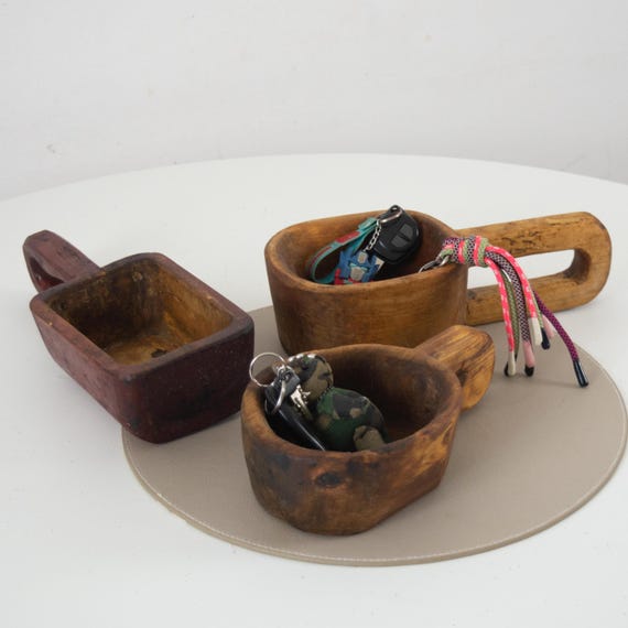 A genuine primitive-carved wooden 'purnoli' bowl with handle — the kind of tactile, aged folk-craft object that makes a entryway feel like it has a real story.