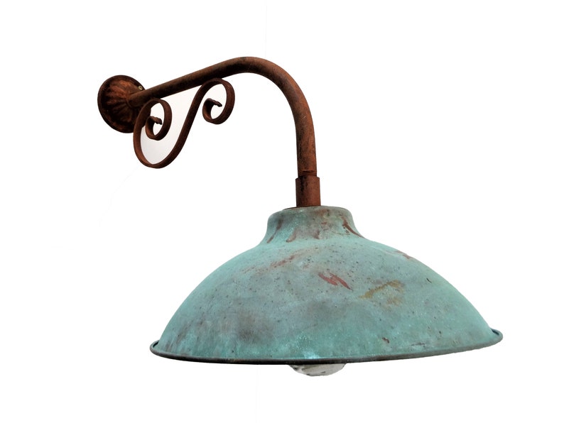 May include: A rusty metal outdoor wall light fixture with a green, weathered, dome-shaped shade.