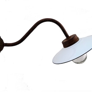 May include: A white enamel wall-mounted light fixture with a curved metal arm and a clear glass bulb.