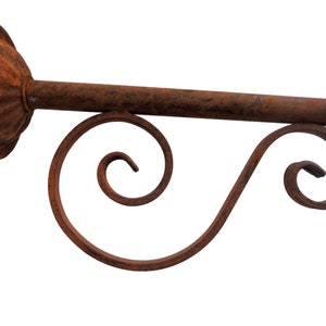May include: Rustic metal wall mount with a decorative scroll design. The mount is made of iron and has a rusty finish.