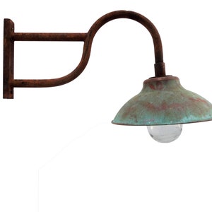 May include: A rusty metal wall-mounted light fixture with a green copper-colored shade and a clear glass light bulb.