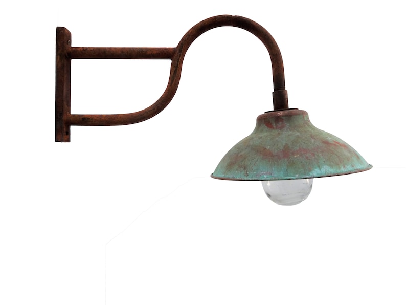 May include: A rusty metal wall-mounted light fixture with a green copper-colored shade and a clear glass light bulb.