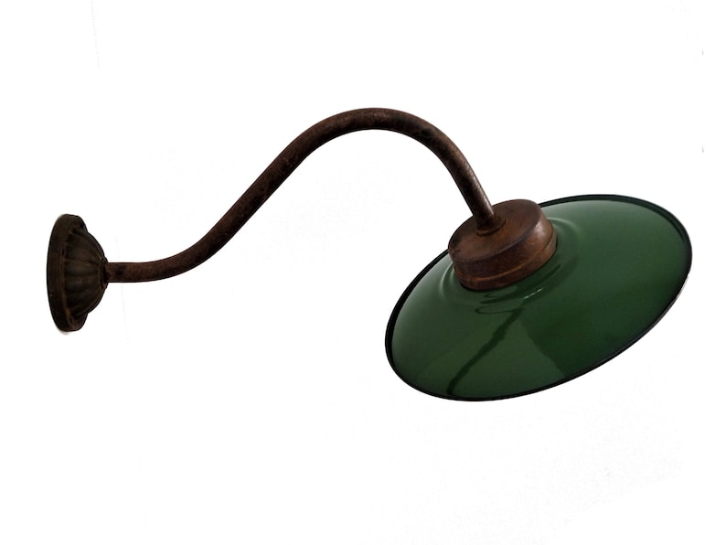 May include: A green metal wall sconce with a curved arm and a round base. The sconce has a rustic, industrial look.