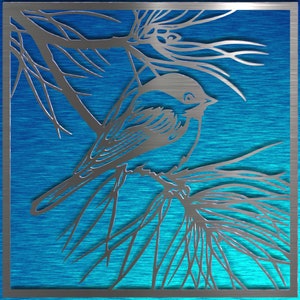 May include: A silver metal wall art piece featuring a bird perched on a branch, set against a blue background. The bird and branches are cut out of the metal, creating a detailed silhouette. The artwork is framed with a silver border.