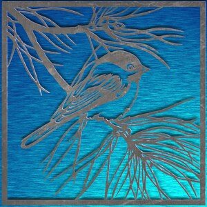 May include: A metal art piece featuring a bird perched on a branch, set against a textured blue background. The bird and branches are cut from metal, creating a silhouette effect. The artwork is framed in a square.