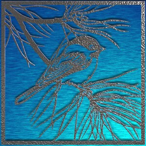 May include: A silver-colored bird and branch design against a blue background. The bird is perched on a branch with pine needles. The image has a square frame with a textured border.