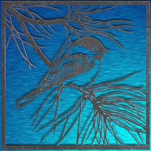 May include: A metal bird silhouette perched on a branch, set against a textured blue background. The bird and branches are a dark gray color, framed within a square border. The artwork evokes a nature theme.