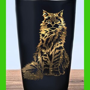 May include: A black stainless steel tumbler with a gold glitter design of a cat sitting.