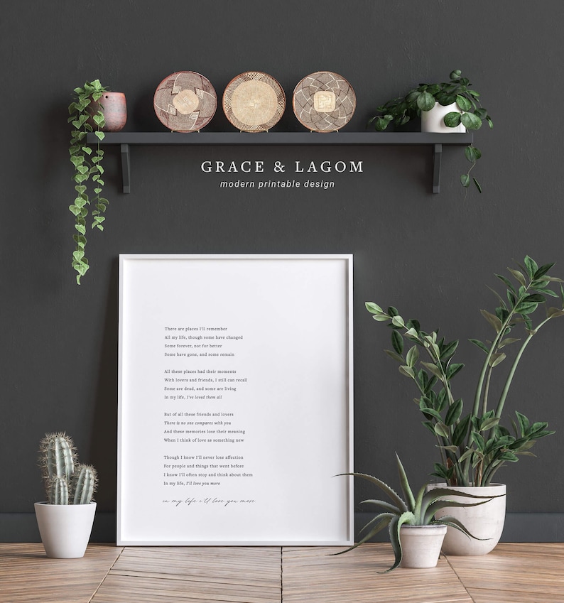 May include: A white framed printable with a poem about remembering people and places. The poem is titled "Grace & Lagom" and is set against a dark gray background with a shelf and plants.