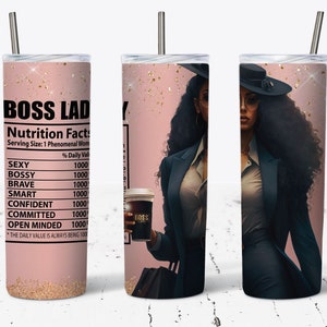May include: A pink and gold tumbler with a black and white illustration of a woman wearing a hat and a suit. The tumbler has a nutrition facts label that reads "Boss Lady" with a list of qualities and a percentage daily value of 1000 for each.