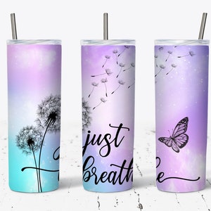 May include: Three stainless steel tumblers with a purple and blue ombre background. The tumblers feature a dandelion design with the words "Just Breathe" on one tumbler and a butterfly on another.