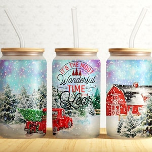 May include: Three insulated tumblers with lids and straws. The tumblers feature a winter scene with a red truck, a red barn, and snow-covered trees. The tumbler in the center has the text "It's the most Wonderful Time of the Year" in a festive font.