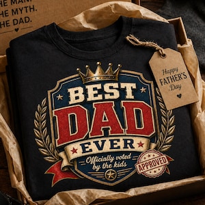 May include: Black t-shirt with a graphic that reads "BEST DAD EVER" in red and blue, with a gold crown and laurel wreath design. Includes a tag that says "Happy FATHER'S Day". The shirt is in a gift box.