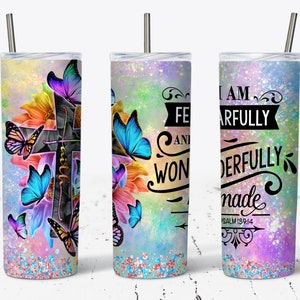 May include: A stainless steel tumbler with a colorful design featuring butterflies, flowers, and a cross. The tumbler has a quote that reads "I am fearfully and wonderfully made Psalm 139:14".