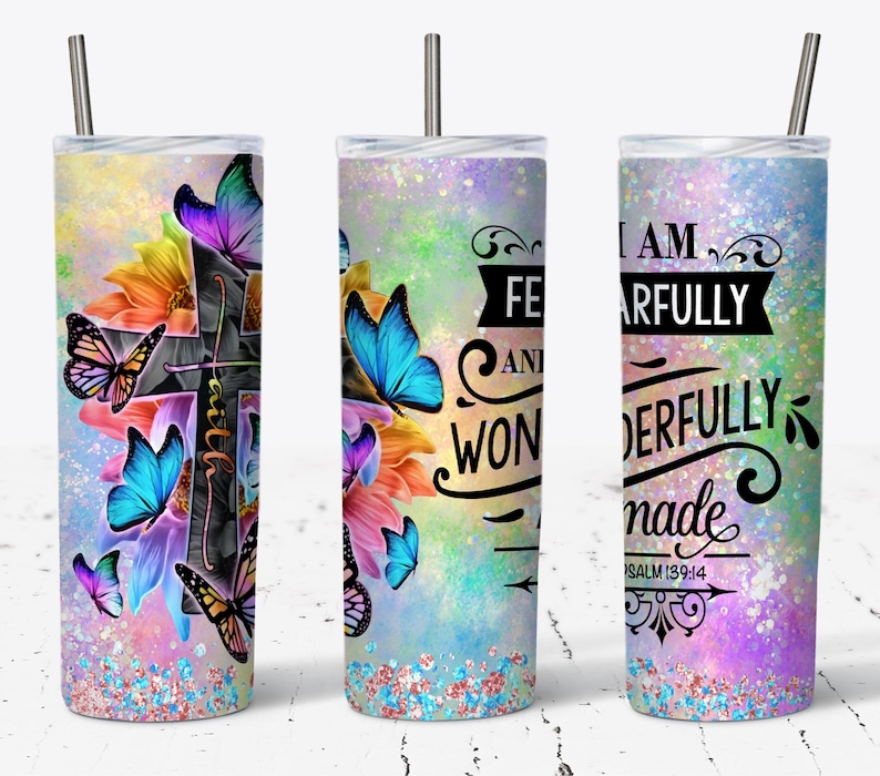 May include: A stainless steel tumbler with a colorful design featuring butterflies, flowers, and a cross. The tumbler has a quote that reads "I am fearfully and wonderfully made Psalm 139:14".