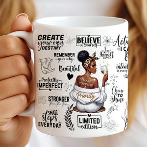 May include: White ceramic mug with a black and white design featuring a woman with a crown of flowers, a glass of wine, and inspirational quotes such as "Create your own destiny", "Believe in yourself", "Love yourself", "Perfectly imperfect", "Make yourself a priority", "Stronger than the storm", "Small steps everyday", and "Limited edition".