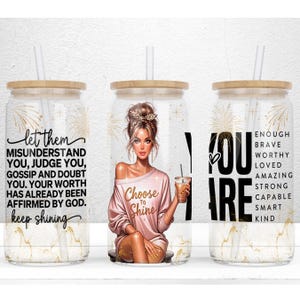 May include: Three glass tumblers with bamboo lids and straws. One tumbler has the text "let them...keep shining". The second tumbler has an illustration of a woman and the text "Choose to Shine". The third tumbler has the text "YOU ARE..." and positive affirmations.