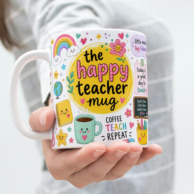 May include: White ceramic mug with the text "the happy teacher mug" in a yellow circle, surrounded by colorful illustrations of a rainbow, stars, and a coffee cup. The mug also has the words "COFFEE TEACH REPEAT".