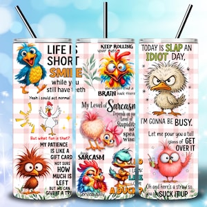 May include: Three stainless steel insulated tumblers with black straws. Each tumbler features a cartoon bird design with humorous phrases like "Life is Short, Smile" and "Today is Slap an Idiot Day." The tumblers have a pink and white checkered background.