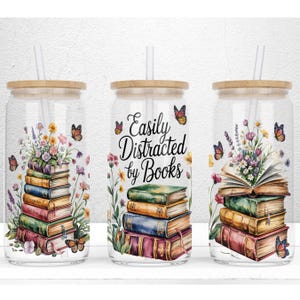 May include: Clear glass tumbler with a wooden lid and straw. The tumbler features a design of stacked books, flowers, and butterflies. The text "Easily Distracted by Books" is displayed on the center tumbler. The design is in watercolor style.