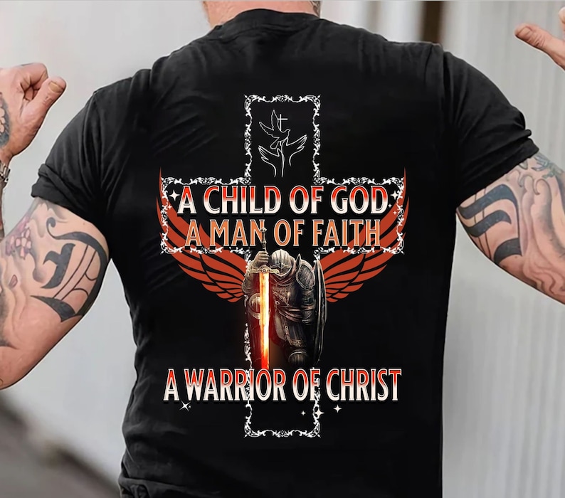 May include: A black t-shirt with a red and orange cross design. The cross features a knight holding a sword, two doves, and the text "A Child of God, A Man of Faith, A Warrior of Christ".