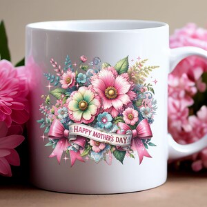 Peut inclure: Mug en c&eacute;ramique blanche avec un motif floral rose, bleu et vert et un ruban rose avec le texte "Joyeuse f&ecirc;te des m&egrave;res".