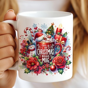 May include: White ceramic mug with a Christmas themed design. The mug features a red and white Santa hat, a snowman, a Christmas tree, candy canes, and a red mug with the text "This is my Christmas magic mug".