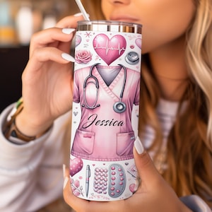 May include: A stainless steel tumbler with a pink nurse's uniform design, a stethoscope, a heart, and the name "Jessica." The tumbler also features decorative hearts, pills, and a pen.