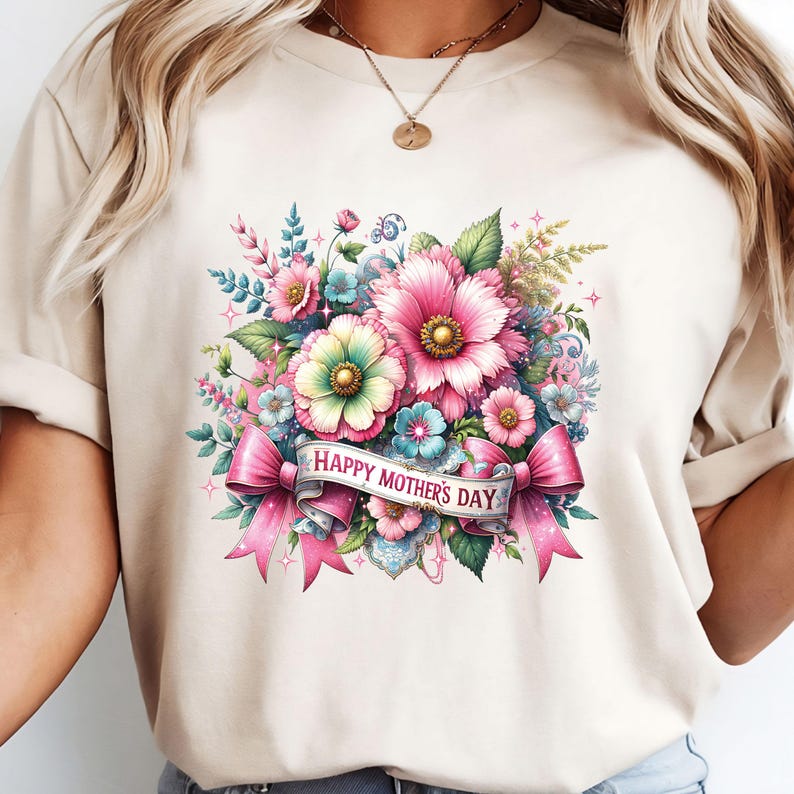 Peut inclure: Un t-shirt beige avec un motif floral et le texte "Happy Mother's Day" sur un ruban rose.
