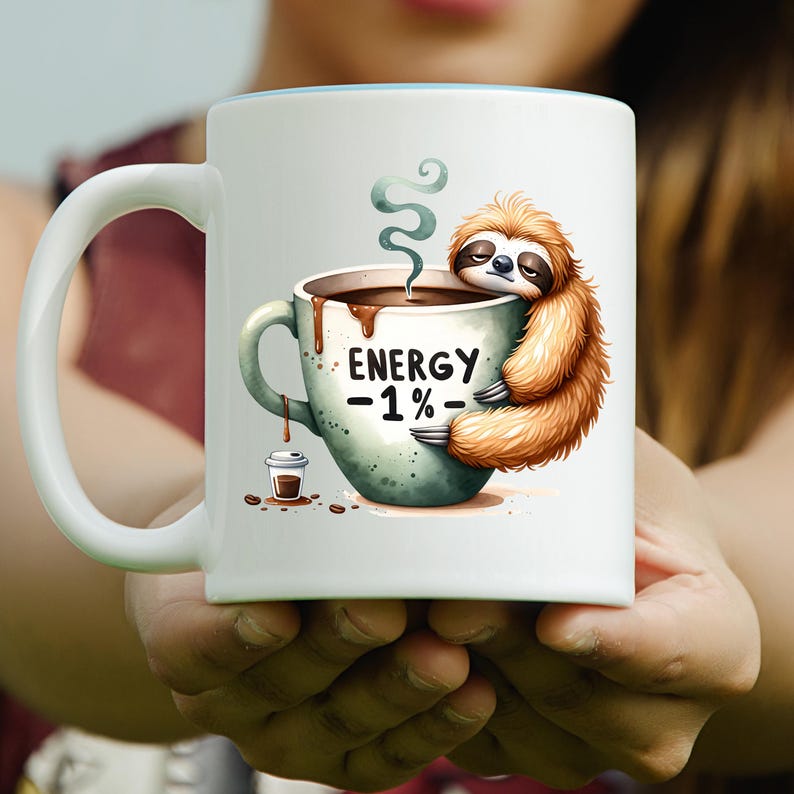 May include: White ceramic coffee mug with a light blue interior. The mug features a cartoon sloth hugging a coffee cup with the text "ENERGY -1%-". A small coffee cup and coffee beans are also depicted.