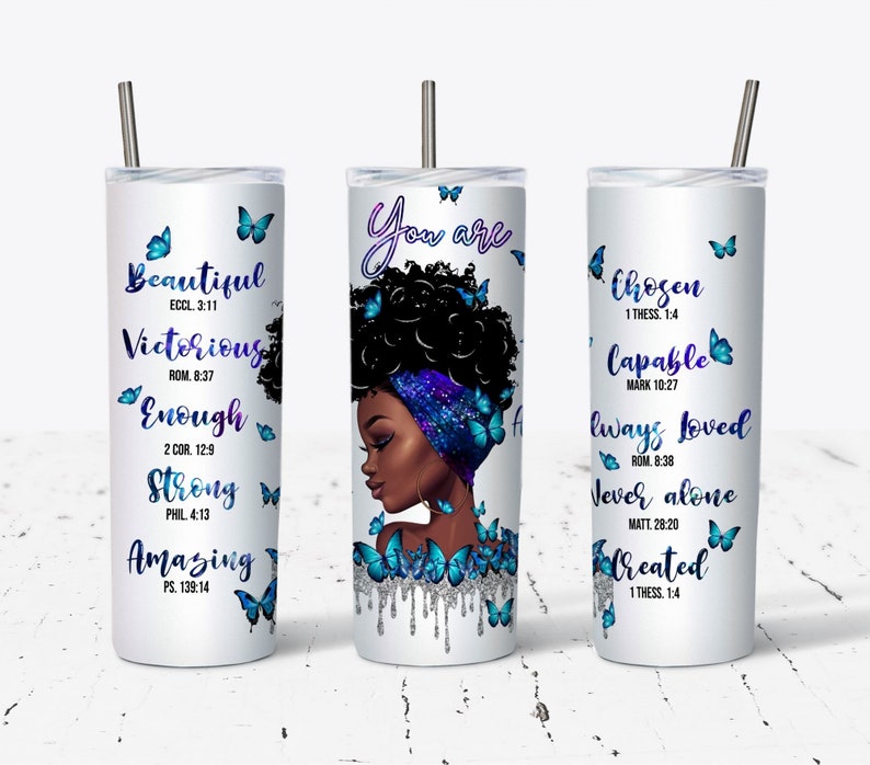 May include: Three white tumblers with stainless steel straws. Each tumbler features a different inspirational quote with bible verses and a black woman with blue butterflies. The first tumbler says "Beautiful, Victorious, Enough, Strong, Amazing" with bible verses. The second tumbler says "You are" with a black woman with blue butterflies. The third tumbler says "Chosen, Capable, Always Loved, Never Alone, Created" with bible verses.