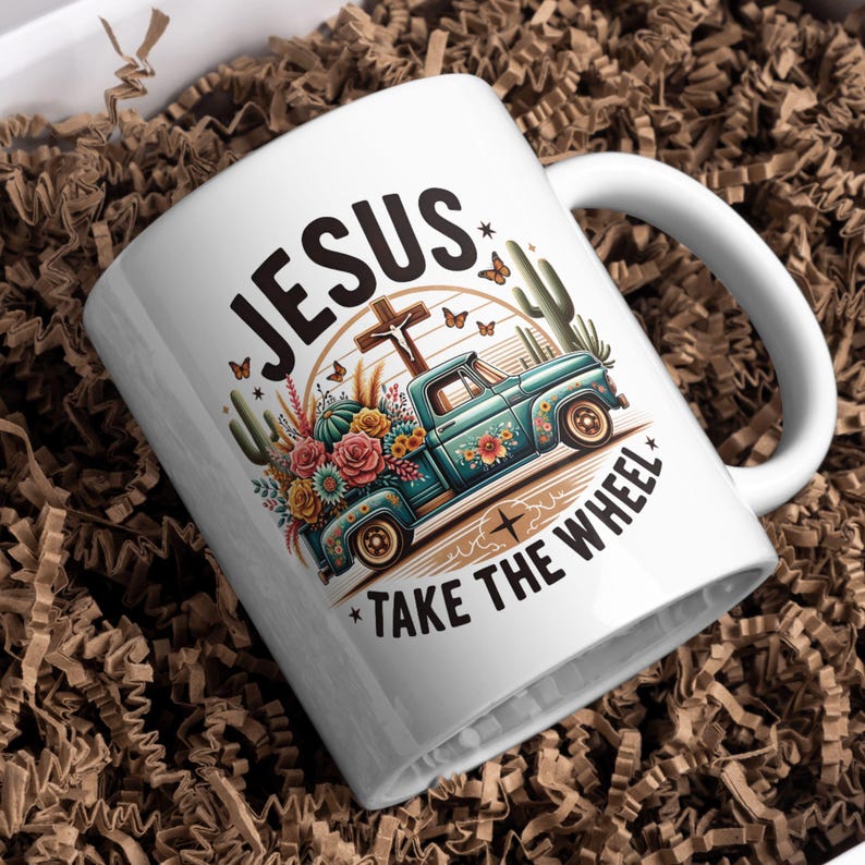 May include: White ceramic mug with a blue pickup truck carrying flowers and the text "JESUS TAKE THE WHEEL" in black lettering.