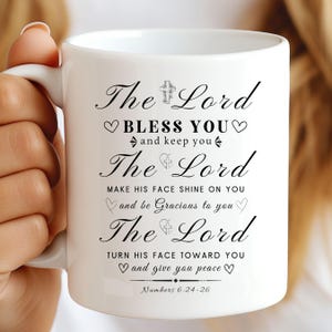 May include: White ceramic mug with a black design that reads "The Lord bless you and keep you. The Lord make his face shine on you and be gracious to you. The Lord turn his face toward you and give you peace. Numbers 6:24-26"