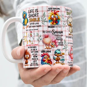 May include: White ceramic mug with cartoon birds and humorous phrases. The mug has a pink and white checkered pattern and is held by a hand. Text includes phrases like "Life is Short, Smile" and "My Level of Sarcasm".