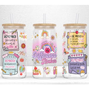 Peut inclure: Trois verres à boire en verre transparent avec des couvercles en bambou et des pailles. Chaque verre à boire présente une citation inspirante différente pour les enseignants, avec des illustrations et des autocollants colorés. Les citations sont "N'oubliez pas que l'enseignement est un travail du cœur", "La vie d'enseignant, un créateur de différence", et "Soyez fier du travail que vous faites, de la personne que vous êtes et de la différence que vous apportez. N'oubliez pas que l'enseignement est difficile, mais vous aussi."