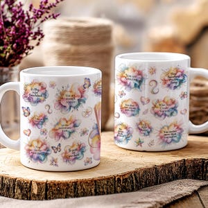 K&ouml;nnte beinhalten: Zwei wei&szlig;e Keramikbecher mit inspirierenden Zitaten und floralen Designs. Die Becher zeigen S&auml;tze wie "Du bist erstaunlich" und "Finde heute etwas Positives." Schmetterlinge und Herzen verzieren die Becher.
