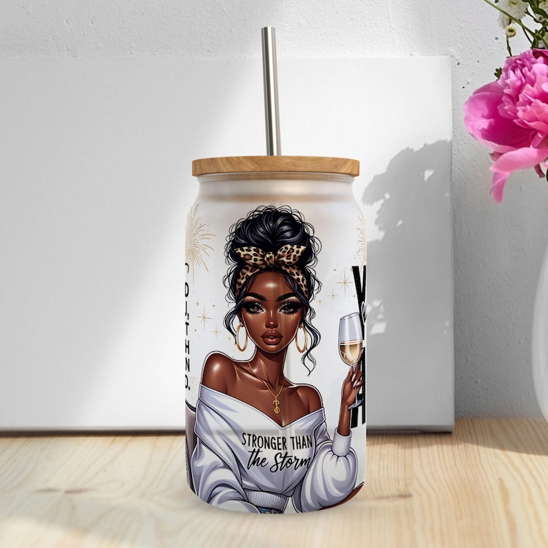 May include: White tumbler with a black and gold design featuring a woman with a leopard print headband and the text "Stronger Than The Storm".