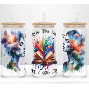 May include: Three glass tumblers with bamboo lids and straws. Each tumbler features a different design: a woman with a galaxy in her head, a book with colorful paint splatters, and a woman with a galaxy in her head. The text on the middle tumbler reads "Spread those pages like a good girl."