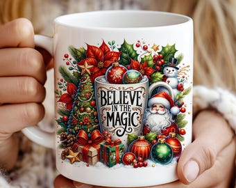 Może przedstawiać: Biały ceramiczny kubek z świątecznym wzorem. Kubek przedstawia choinkę, Świętego Mikołaja, bombki i napis "BELIEVE IN THE MAGIC". Projekt zawiera czerwone, zielone i złote akcenty, tworząc świąteczny motyw.