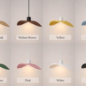 May include: Eight pendant lights in various colors: natural oak, walnut brown, yellow, light blue, dark green, pink, white, and black. Each light has a unique hat-shaped shade and a white or black cord. The labels below each light indicate the color.