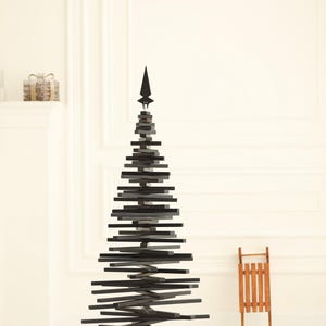 May include: A black wooden Christmas tree with a star on top. The tree is made of stacked wooden slats and has a black metal base.